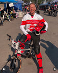 BMX Hall of Fame Stu Thomsen on his SYNDYT bike wearing  his SYNDYT white sports jersey with red large stripe around chest back and arms with a big SYNDYT "S"Logo under it.